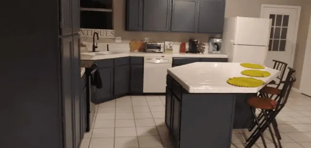 a kitchen with a sink a stove a refrigerator and cabinetry