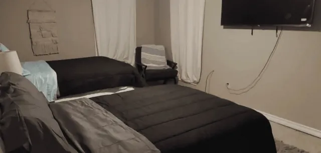 a bedroom with a bed and a television