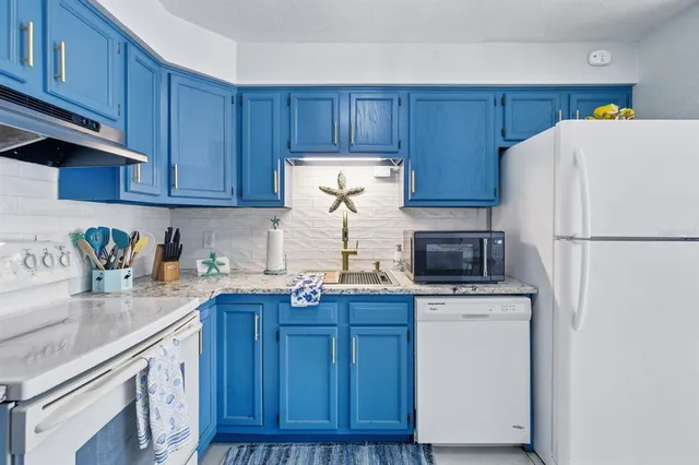 a kitchen with kitchen island wooden cabinets a sink and white appliances
