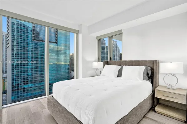 a large bed sitting in a bedroom next to a window
