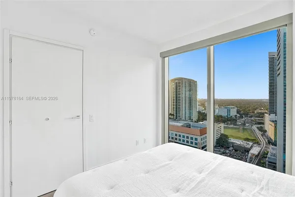 a bedroom with a bed and a large window