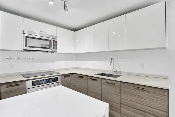 a kitchen with a sink a stove and cabinets