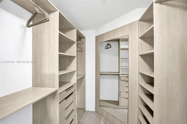 a view of walk in closet with empty racks
