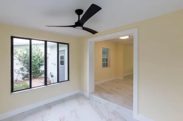 a view of empty room with a ceiling fan and window