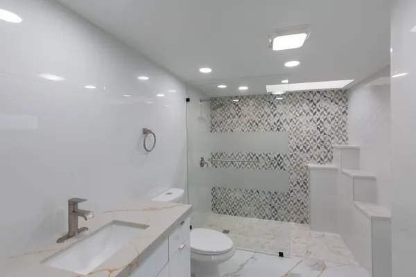a bathroom with a toilet a sink and mirror