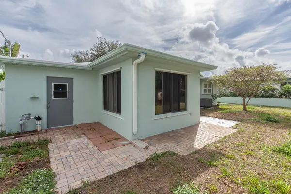 a view of backyard with table and chairs and wooden fence