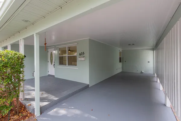 a view of an empty room with a window and potted plants