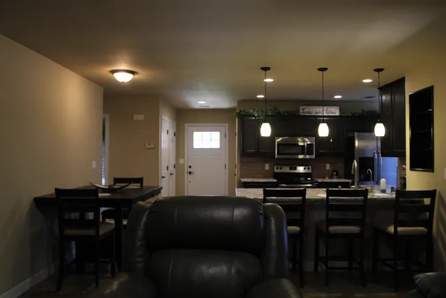 a room with table chairs and a projector screen