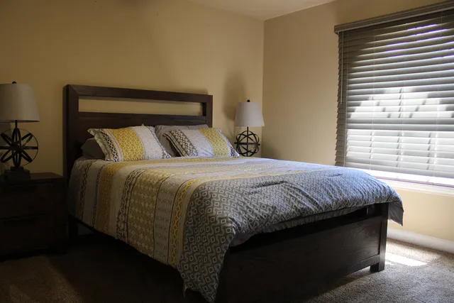 a bed sitting in a bedroom next to a window
