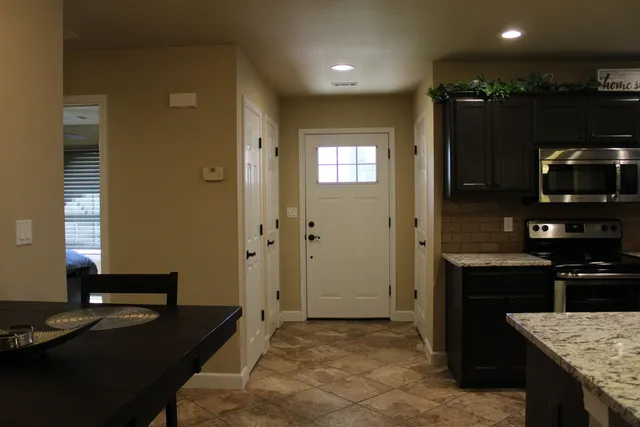 a kitchen with kitchen island granite countertop a sink stove and refrigerator