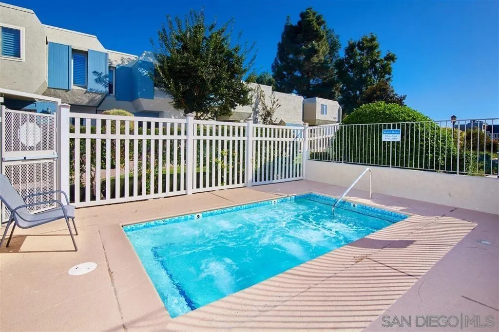 6359 Rancho Mission Road, Unit 7 San Diego, CA 92108 - Photo 22 of 25 a white house with a yard and wooden fence