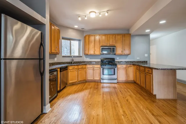 a kitchen with wooden floors and white appliances