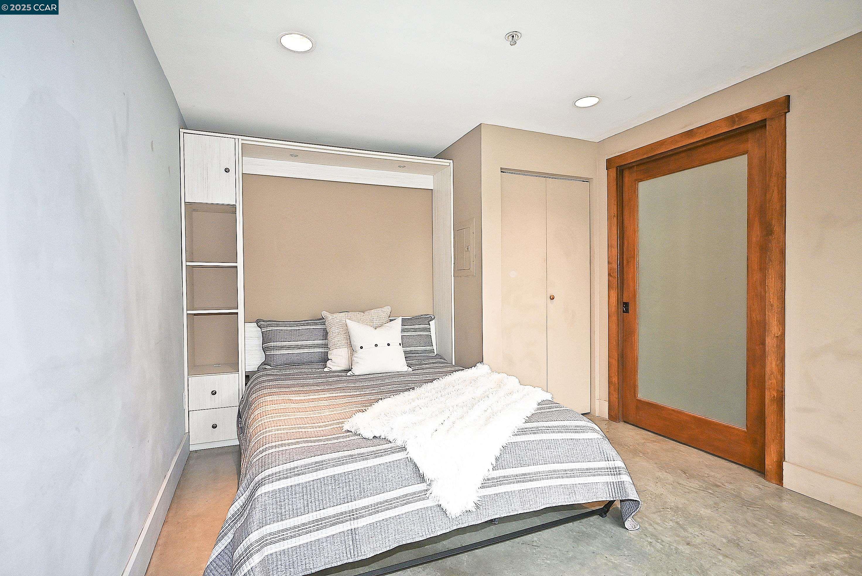 675 8th Street, Unit 15 Oakland, CA 94607 - Photo 23 of 38 a bedroom with a bed and a dresser