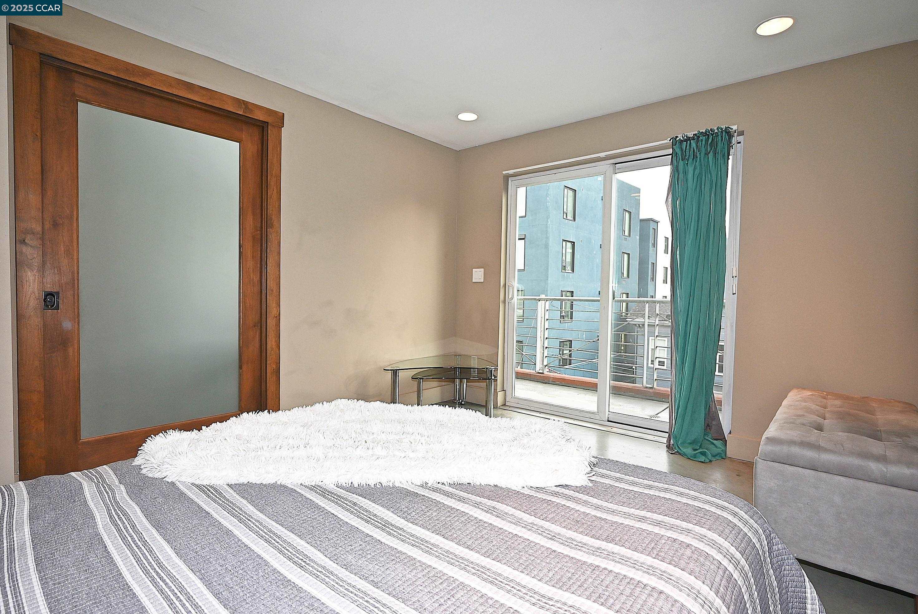 675 8th Street, Unit 15 Oakland, CA 94607 - Photo 25 of 38 a bedroom with a bed and a large window