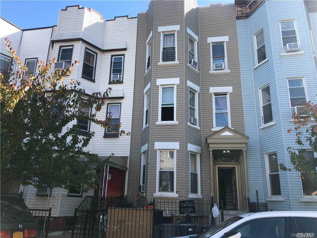 a front view of a multi story building with yard