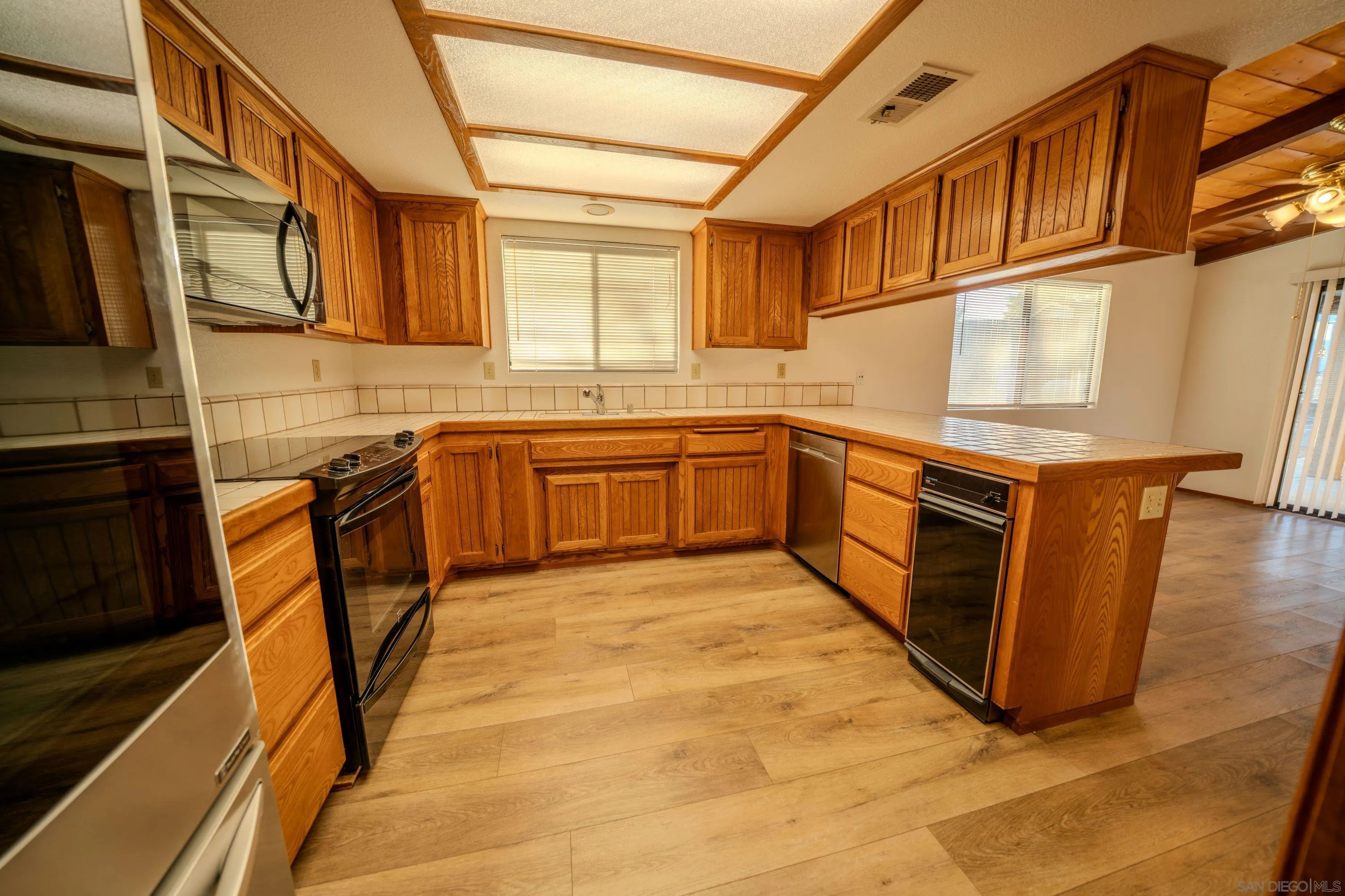 526 Brazos Street Ramona, CA 92065 - Photo 22 of 56 a kitchen with stainless steel appliances granite countertop a stove a sink and a microwave