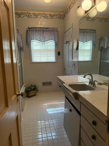 a bathroom with a granite countertop sink a mirror and a vanity
