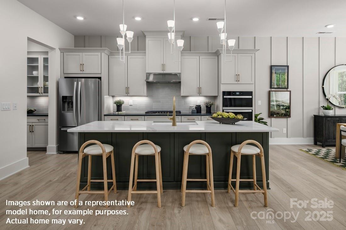 1081 Pinecone Avenue, Unit 213 Indian Land, SC 29707 - Photo 4 of 19 a kitchen with stainless steel appliances granite countertop a stove a sink a refrigerator and a microwave