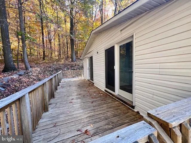 a view of a wooden deck and a backyard