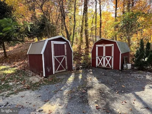 a view of backyard with large trees and wooden fence