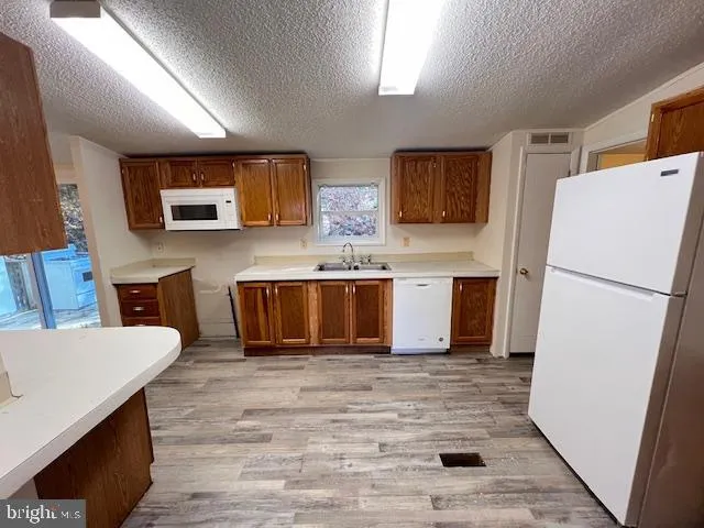 a kitchen with stainless steel appliances granite countertop a refrigerator sink and stove
