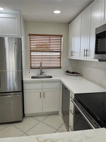 a kitchen with a sink cabinets and stainless steel appliances