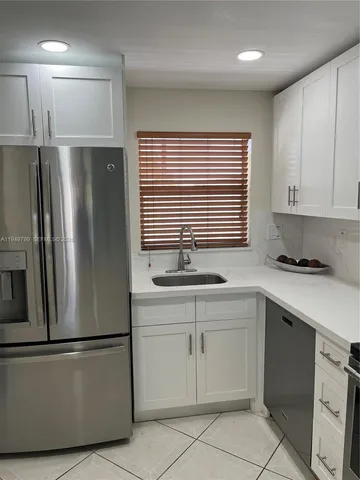 a kitchen with a refrigerator sink and cabinets