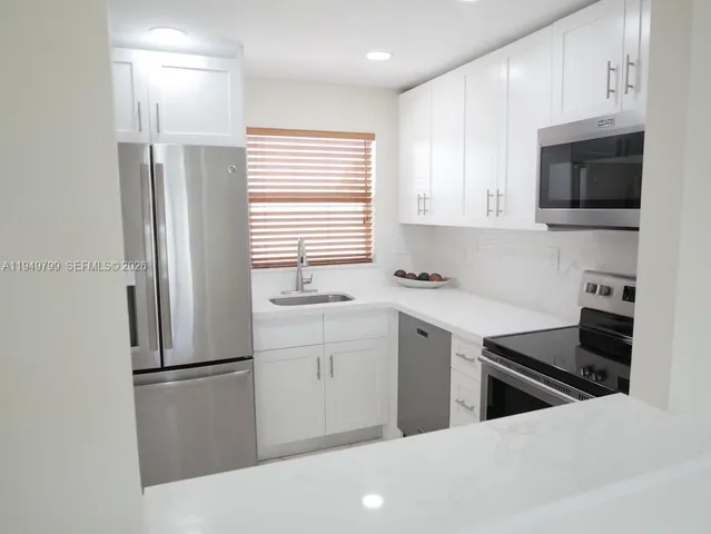 a kitchen with stainless steel appliances a refrigerator sink and microwave
