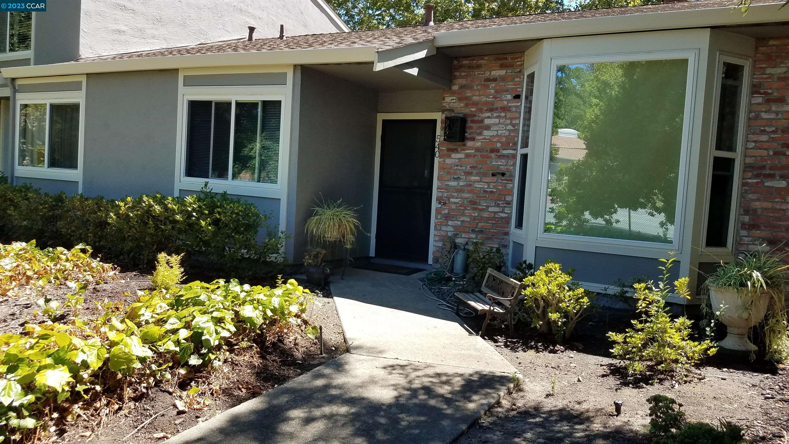 a front view of a house with a yard and flowers