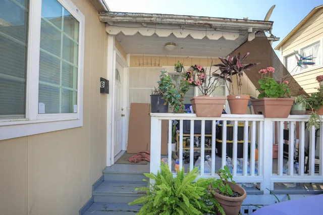 a view of a house with backyard and wooden fence