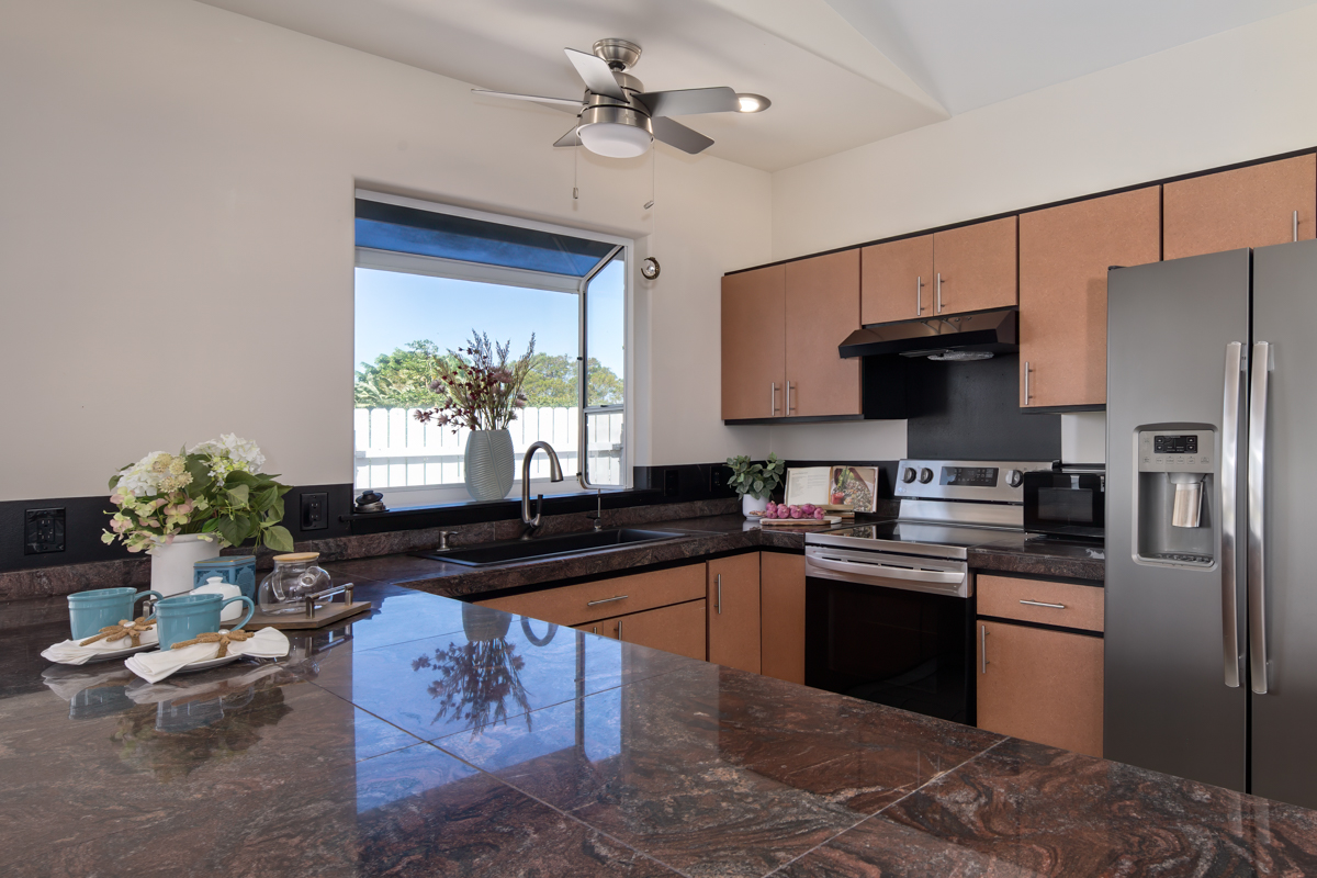 68-1704 Akaula Court Waikoloa, HI 96738 - Photo 12 of 30 a kitchen with granite countertop a sink stove and refrigerator