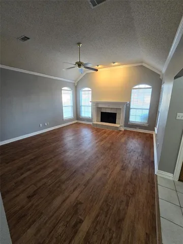 a view of empty room with wooden floor and fireplace