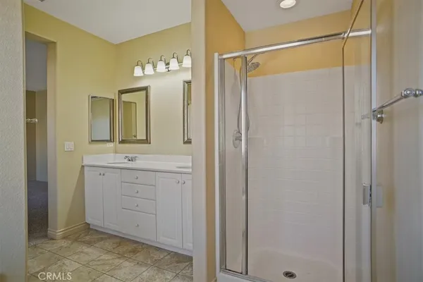 a bathroom with a double vanity sink mirror and shower