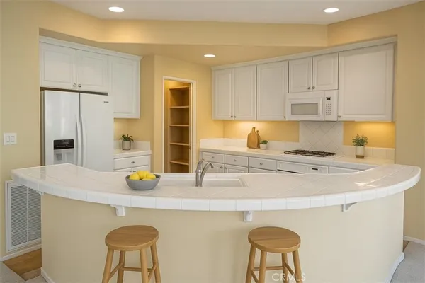 a kitchen with a sink a stove and chairs