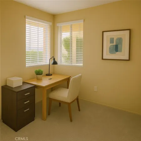 a view of a workspace with furniture and a window