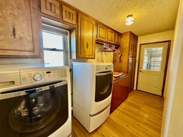 a utility room with wooden floor and furniture
