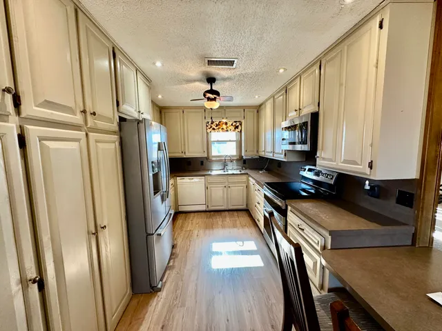a kitchen with stainless steel appliances a refrigerator a stove a sink and a microwave
