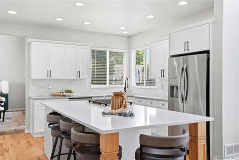 a kitchen with stainless steel appliances a dining table and chairs