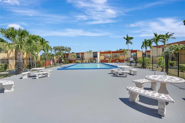 a swimming pool with outdoor seating and a shower