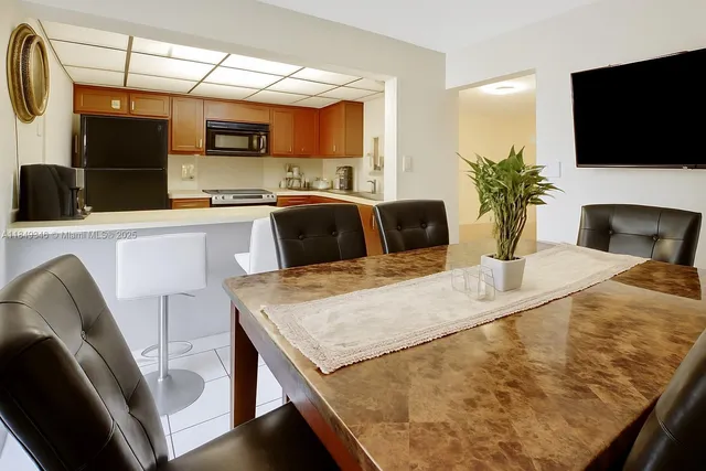 a kitchen with a table chairs refrigerator and microwave