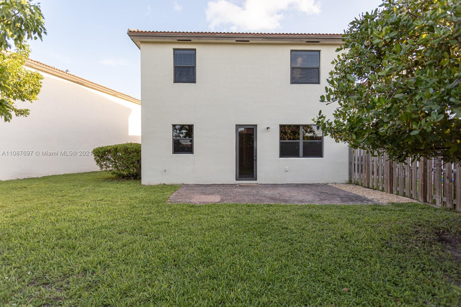 9019 Southwest 227th Terrace Cutler Bay, FL 33190 - Photo 5 of 9 a backyard of a house with plants and garage