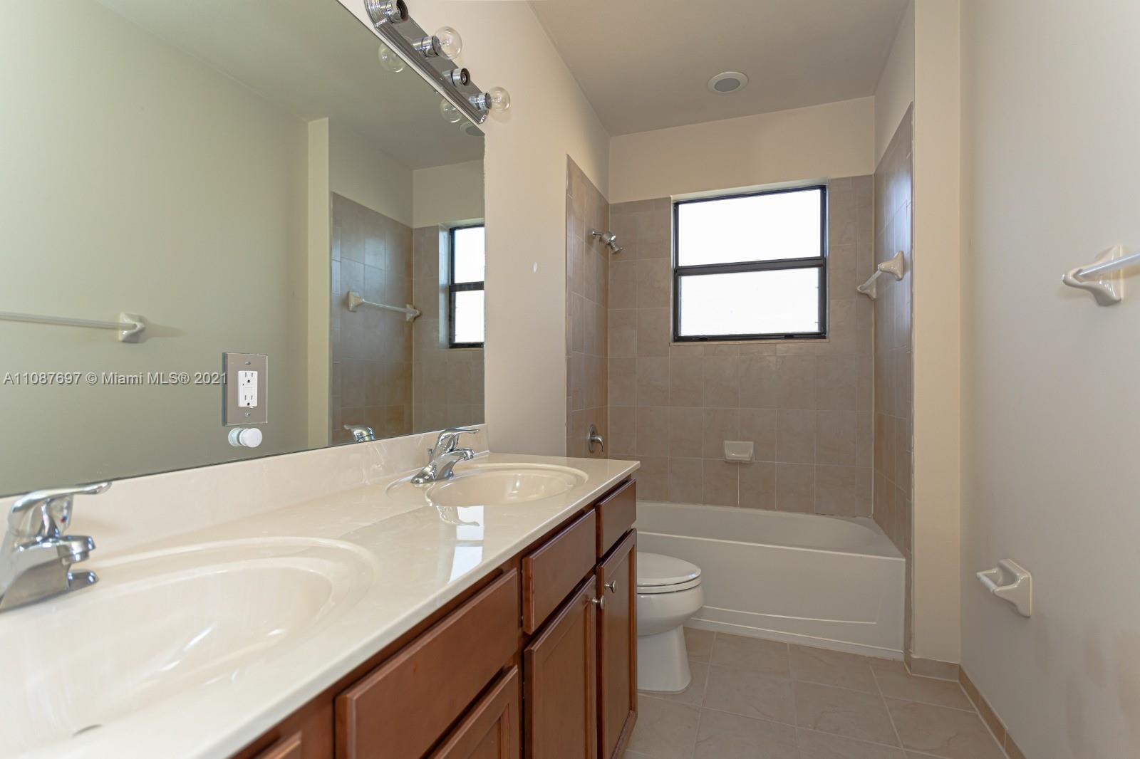 9019 Southwest 227th Terrace Cutler Bay, FL 33190 - Photo 9 of 9 a bathroom with a sink a toilet and shower