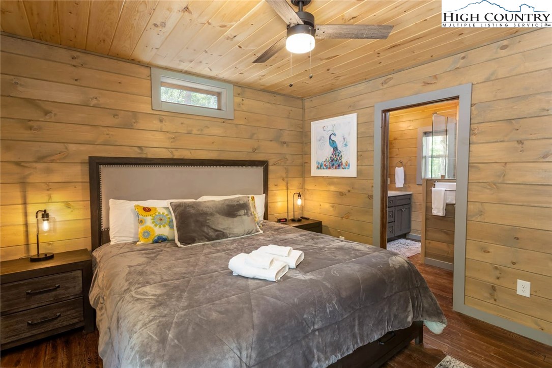 141 Rhododendron Drive Beech Mountain, NC 28604 - Photo 16 of 27 a bedroom with a bed and a chandelier