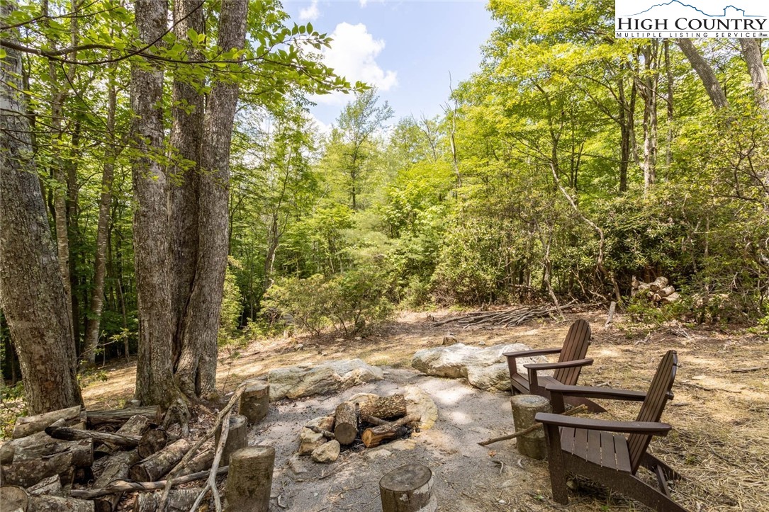 141 Rhododendron Drive Beech Mountain, NC 28604 - Photo 26 of 27 a backyard of a house with table and chairs