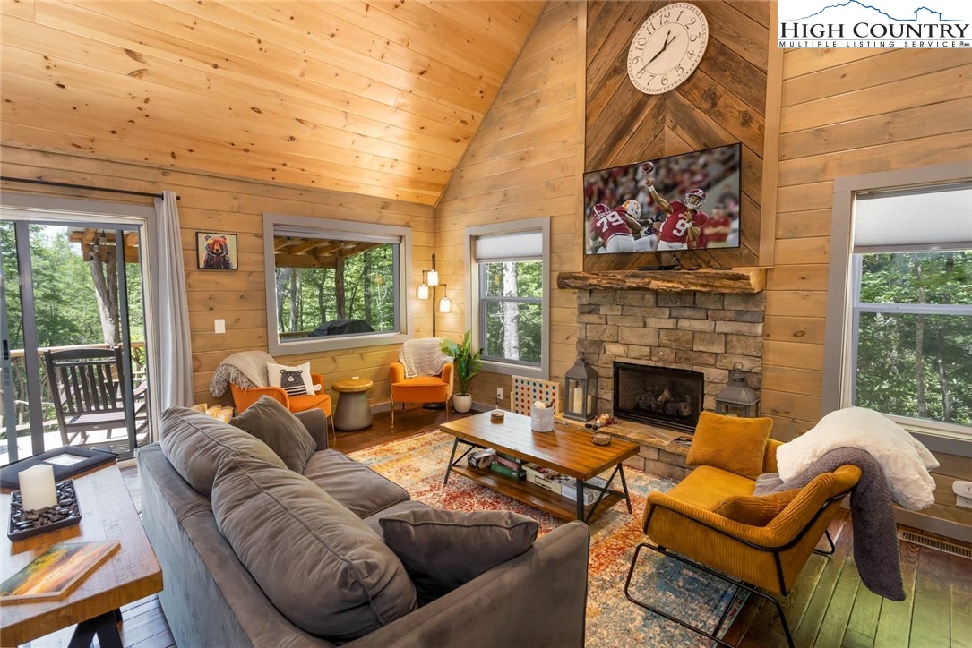 141 Rhododendron Drive Beech Mountain, NC 28604 - Photo 4 of 27 a living room with furniture a fireplace and a flat screen tv