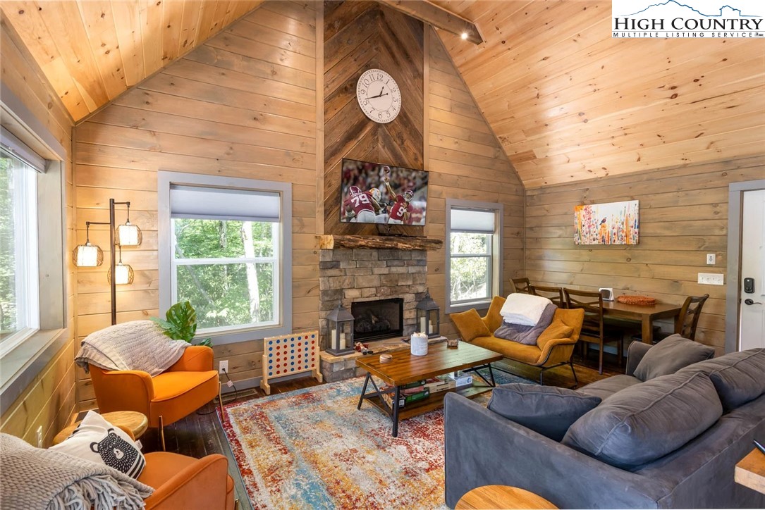 141 Rhododendron Drive Beech Mountain, NC 28604 - Photo 5 of 27 a living room with furniture a fireplace and a large window