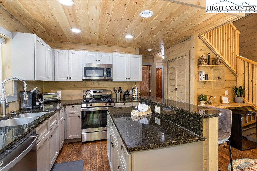 141 Rhododendron Drive Beech Mountain, NC 28604 - Photo 9 of 27 a kitchen with kitchen island granite countertop a sink stove and cabinets