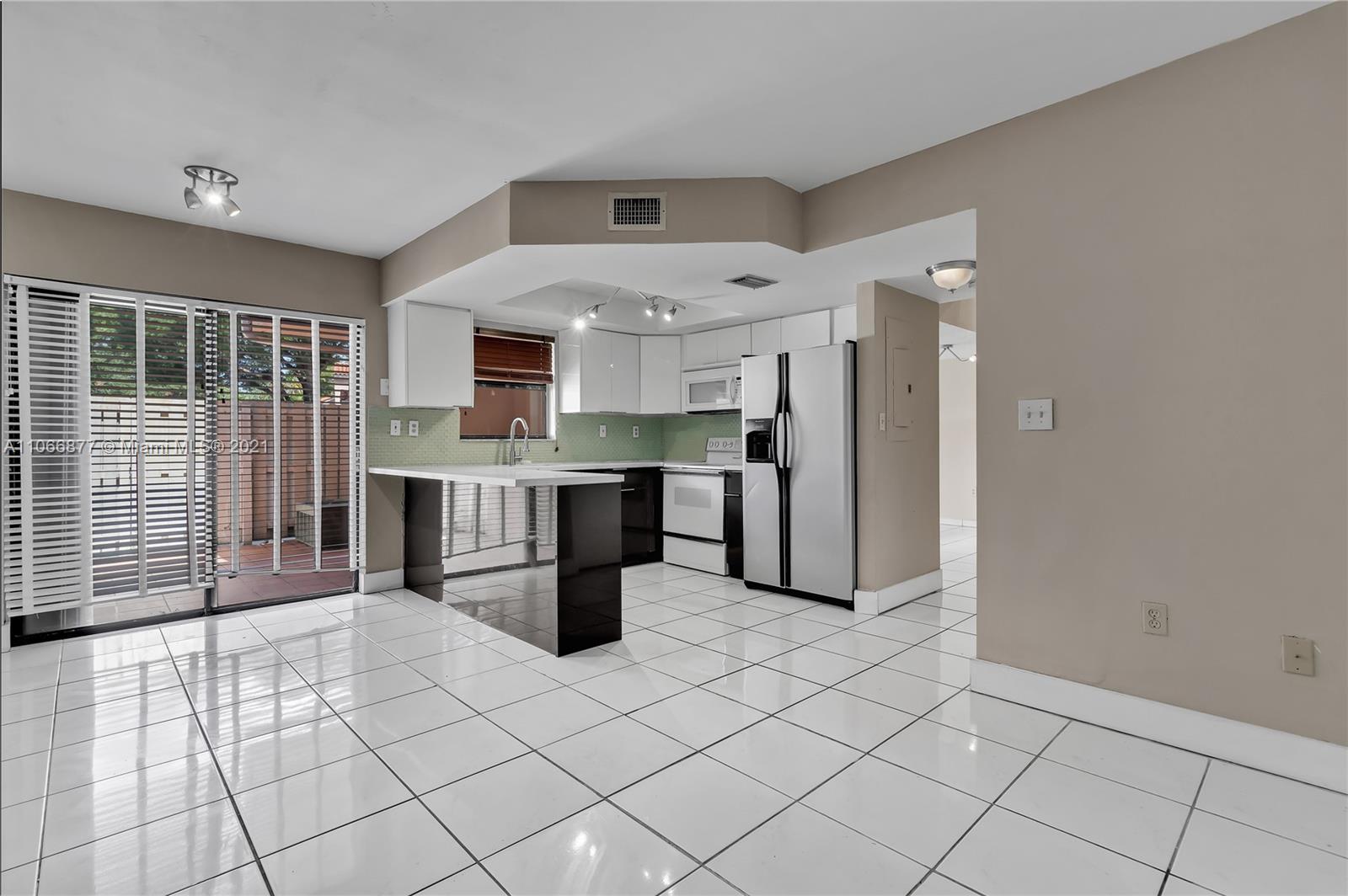 11820 Southwest 80th Street, Unit 312 Miami, FL 33183 - Photo 13 of 43 a kitchen with stainless steel appliances a refrigerator sink and cabinets
