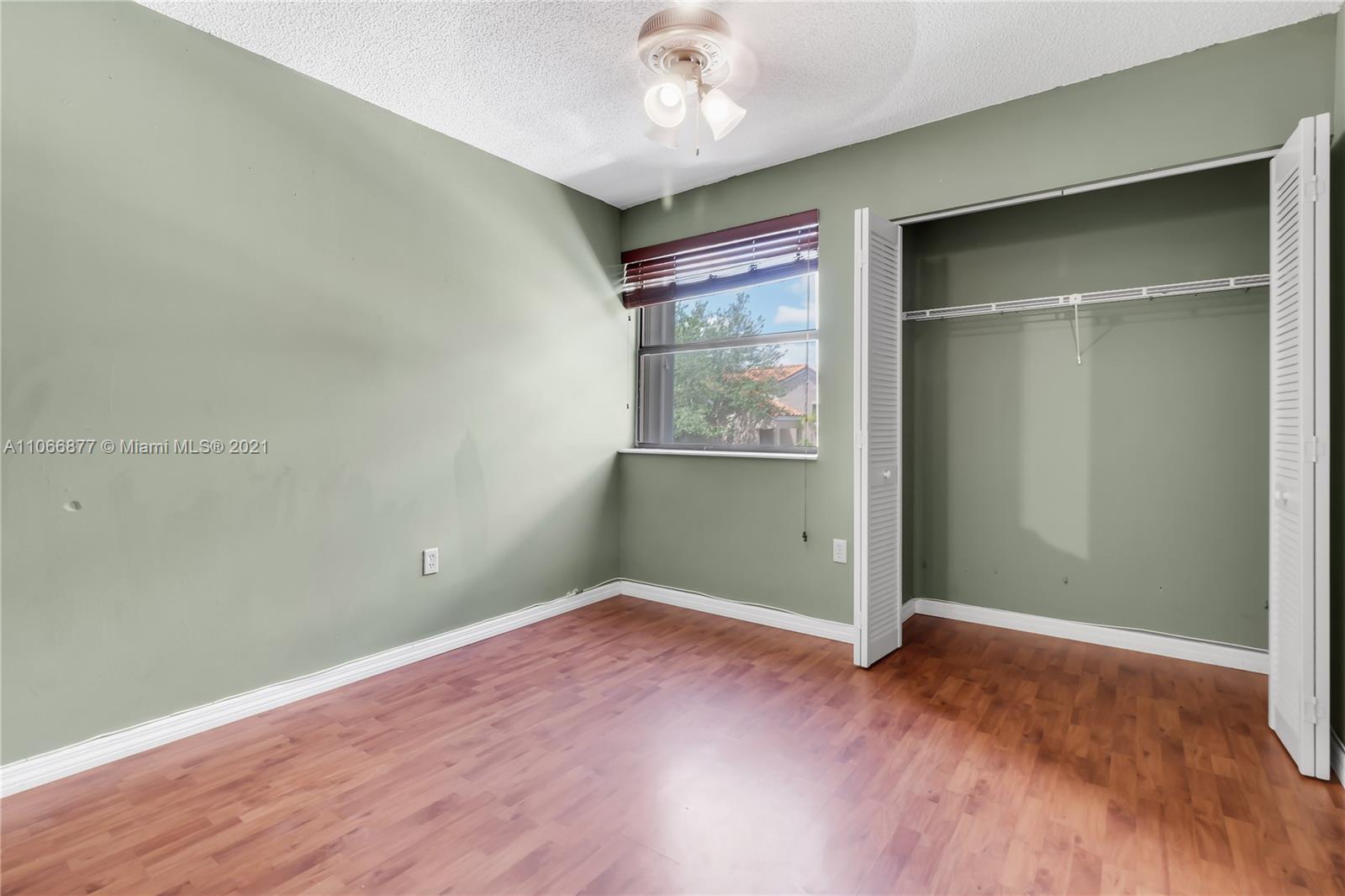 11820 Southwest 80th Street, Unit 312 Miami, FL 33183 - Photo 23 of 43 an empty room with wooden floor and windows