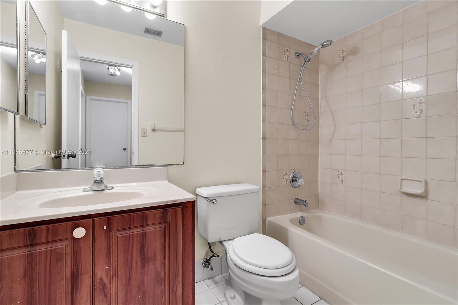 11820 Southwest 80th Street, Unit 312 Miami, FL 33183 - Photo 26 of 43 a bathroom with a sink a toilet and shower